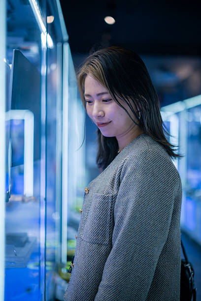 istock Young woman playing crane game at night 2228619363