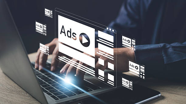 istock Person working on a laptop with multiple online advertisement banners displayed, representing internet marketing, digital ads, and media promotion strategy. 2228619940