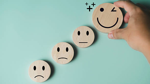 istock Hand placing happy smiley face icon among neutral and sad faces, concept for positive thinking, mental health improvement, happiness, and emotional wellbeing with copy space. 2228620038