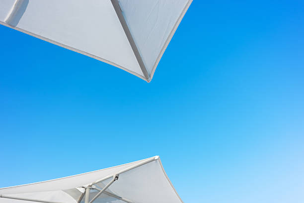Beach umbrella against blue morning sky.
