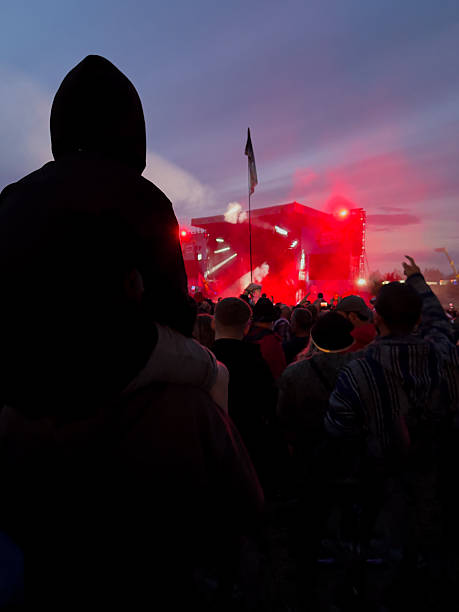 istock Crowd watching night concert with red stage lights 2228622813