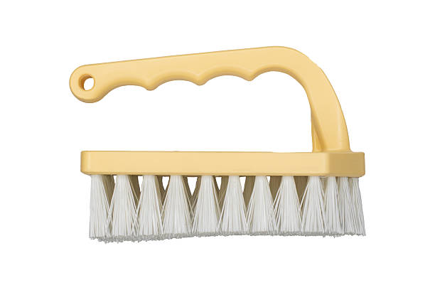 Beige cleaning brush with ergonomic handle is isolated.