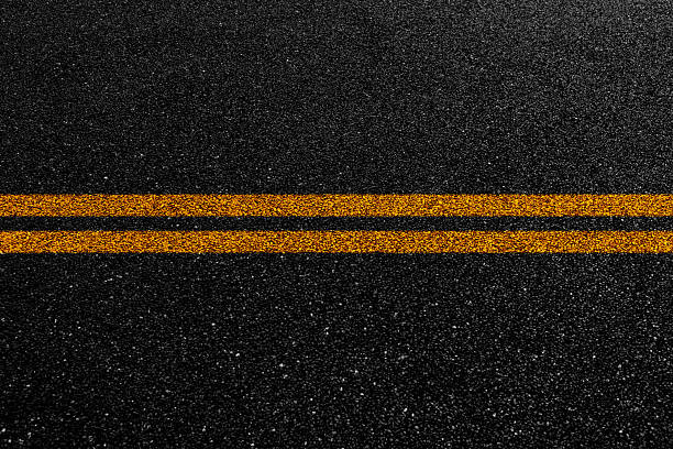 istock Double orange line on asphalt road 2228630217