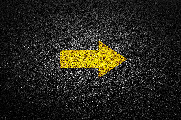 istock Yellow arrow on black asphalt road 2228630218