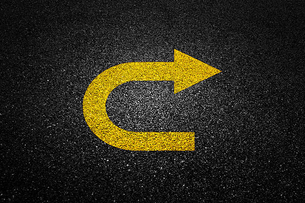 Yellow arrow on black asphalt road
