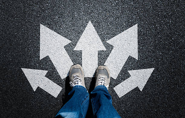 istock Taking decisions for the future, man standing with multitude of arrows in different direction 2228630352