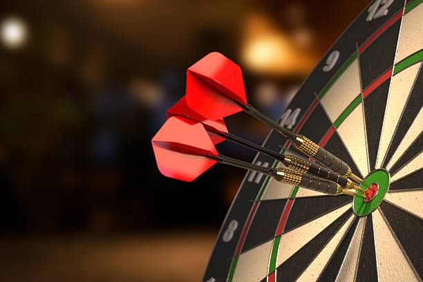 Dartboard with three darts in the bullseyes.