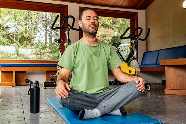 istock Mid adult man meditating in an exercise room 2228638738
