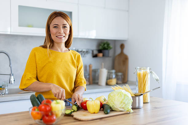 istock Culinary Bliss: Woman Preparing Fresh Vegetables Smiling 2228640780