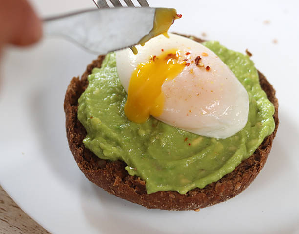 Avocado toast with poached egg and spices on a white plate