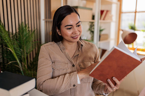 istock Woman Browsing Book Near Bookshelf 2228644987