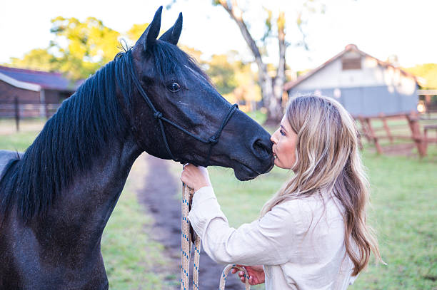 istock Woman and Horse Sharing a Bond in a Tranquil Farm Setting 2228645255