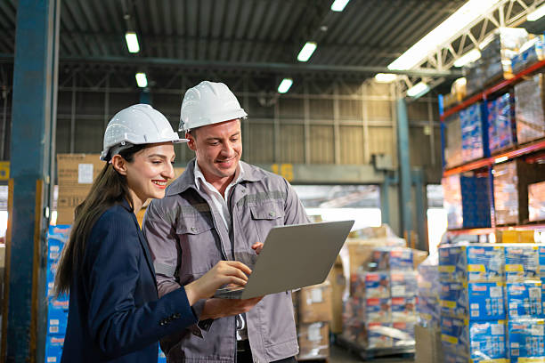 istock Warehouse Manager  and supervisor in inventory data on a laptop amid stacked pallets. 2228647740