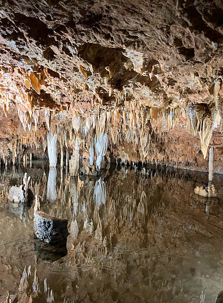 istock Stalactite cave formations above a pool of water 2228648234