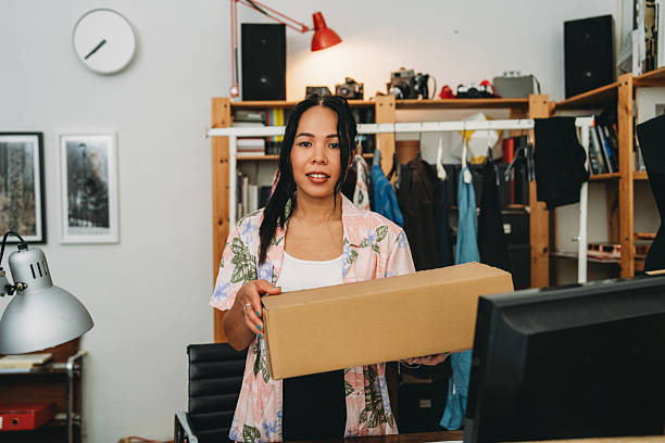 istock Young entrepreneur holding a package in her store 2228648773