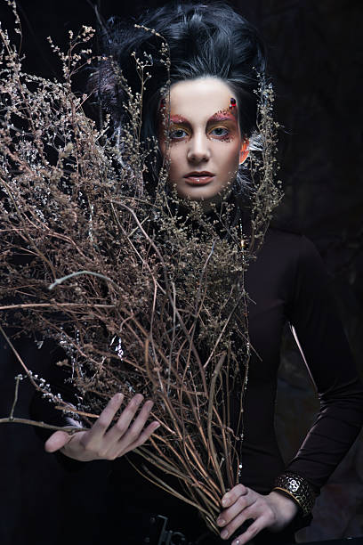 istock Young woman with bright make up with dry branches 2228649689