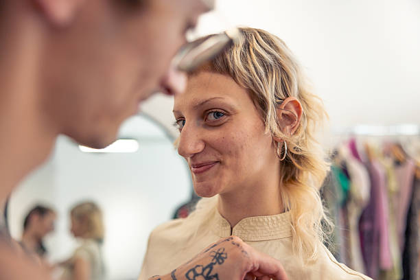 istock Non-binary designer is fitting an elegant dress on  young beautiful woman. 2228651417