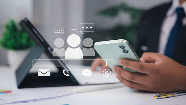 istock Businessman using smartphone with email, phone, chat and group icons, digital communication and online customer support concept in office setting. 2228651446