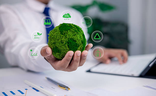 istock sustainability concept in office. Businessman holding green moss globe with net zero, carbon footprint, recycle, and renewable energy icons. 2228651450