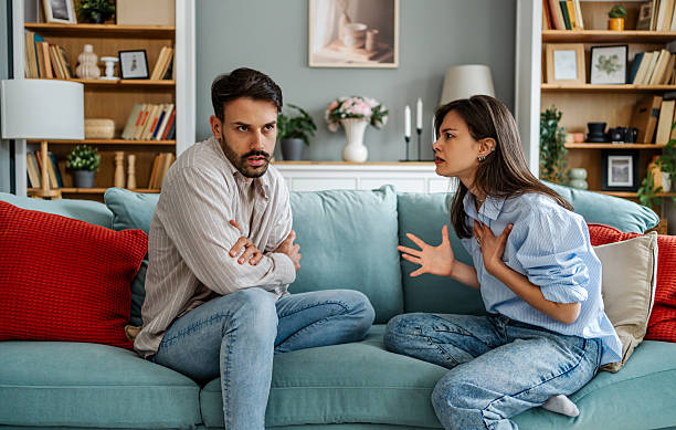 istock Young couple arguing while sitting on sofa at home 2228653676