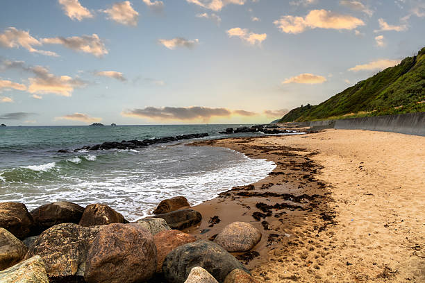 istock Sea shoreline with rocky breakwater and sunset sky with clouds 2228654145