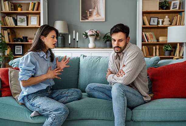 istock Young couple arguing while sitting on sofa at home 2228654231