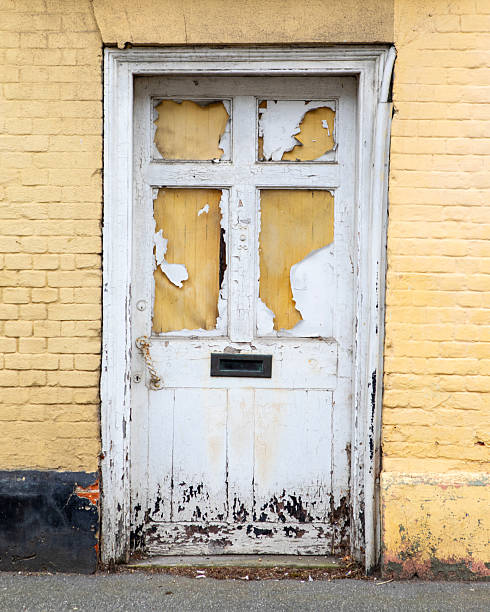 The broken front door of a derelict property in the United Kingdom.