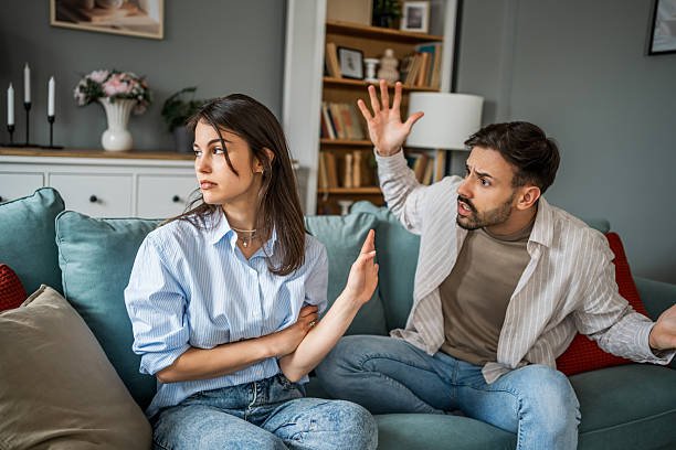 istock Young couple arguing while sitting on sofa at home 2228654433