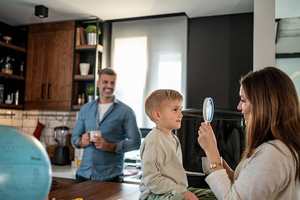 istock Happy family playing with magnifying glass in kitchen 2228654977