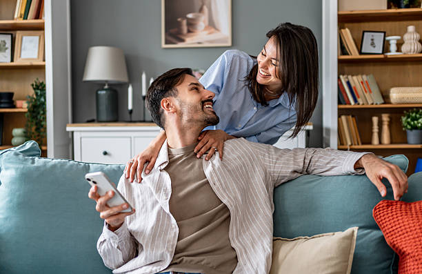 istock Young couple relaxing at home, embracing on sofa 2228655146