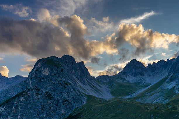 Alps mountains scenic landscape in summer. Austrian Alps scenery trekking path among the high mountain peaks in summer. Green mountain valleys with rocky peaks and lake in the Alps in Austria