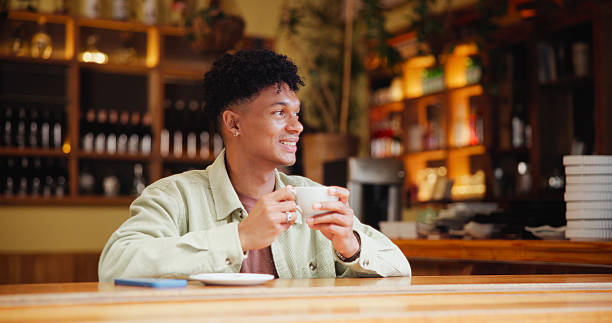 istock Man, coffee and thinking with smile at cafe for memory, drink and relax with inspiration at restaurant. Person, happy and tea cup with reflection, remember and perspective with beverage at diner 2228656182