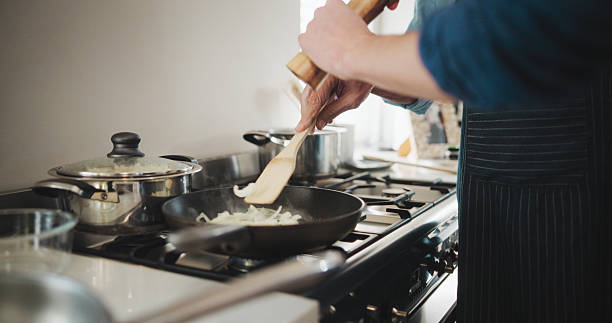 istock Cooking, hands and culinary skills with pan in kitchen, chef or meal prep for dinner or ingredients. Catering business, entrepreneur and person with recipe for nutrition, process and onions to saute 2228656594