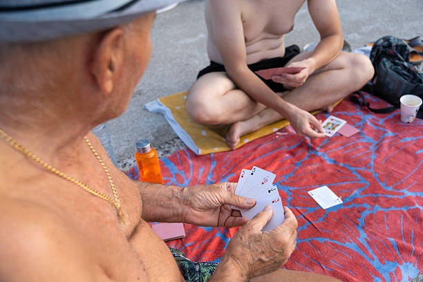 Grandfather and grandson playing a card game by the sea
