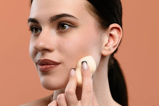 istock Woman Applying Makeup with Sponge for a Flawless Look 2228658104