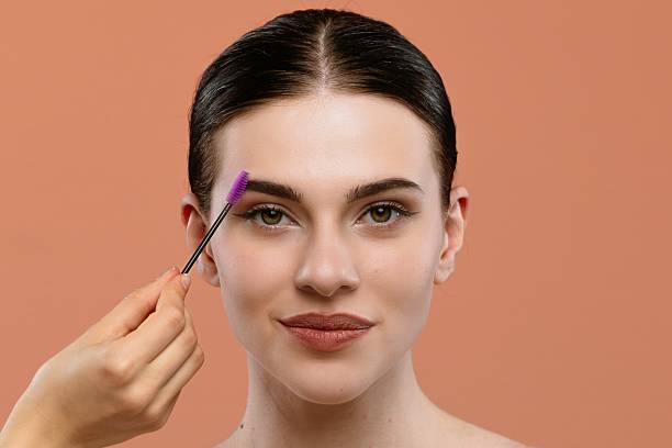 istock Woman Having Her Eyebrow Brushed with a Purple Brush 2228660074