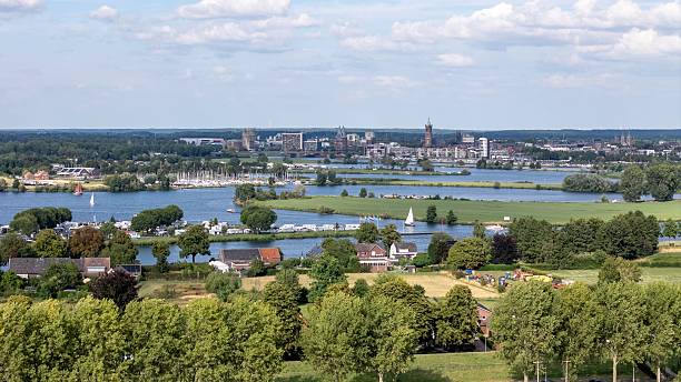 istock Dutch landscape with river and city skyline 2228661620