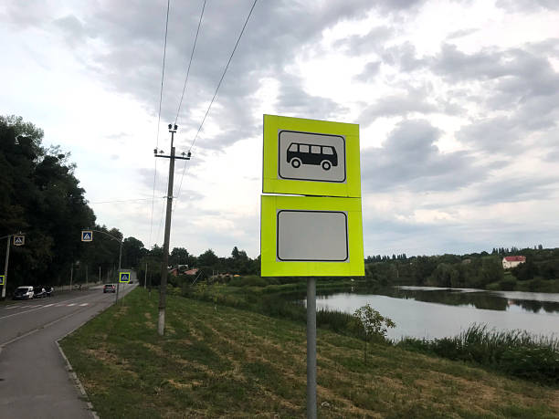 istock Bright bus stop sign near river in rural area 2228663099