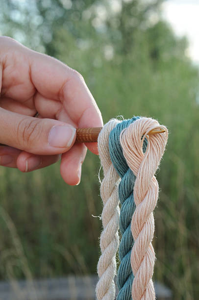 istock A woman's hand holds a rope with knots. 2228669879