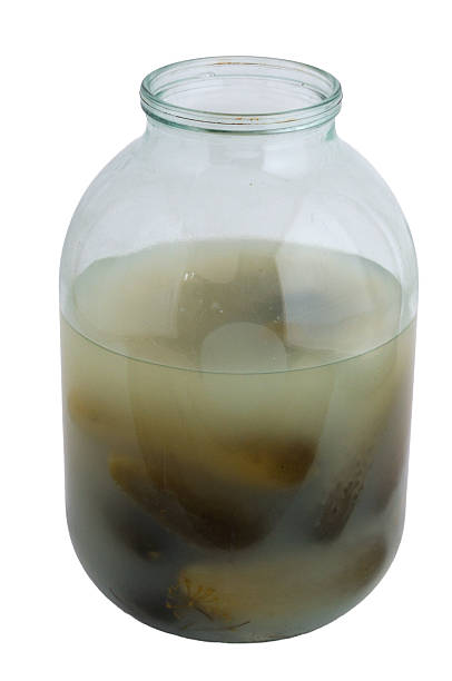 istock A glass jar filled with pickled cucumbers on a white background 2228669885