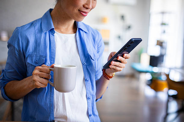 istock Woman Drinking Coffee While Browsing on Smartphone 2228670960