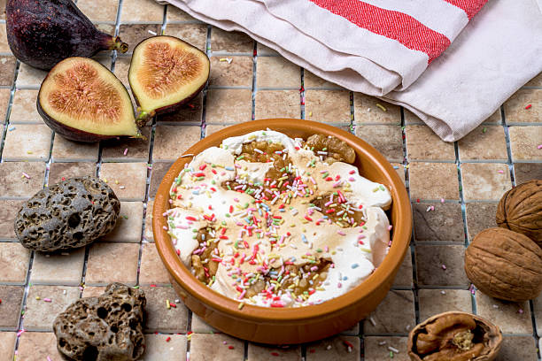 Autumnal dessert with walnuts, figs, and whipped cream, served in a rustic bowl. Seasonal dessert with colorful sprinkles on a ceramic tile background.