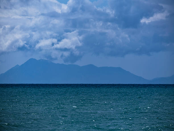 istock Ocean waves, cloudy skies, and distant mountains 2228677103