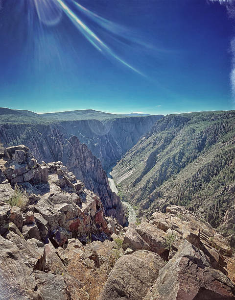 Dramatic canyon landscape with a river, under a vibrant, clear sky.