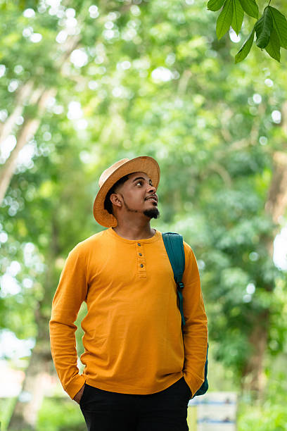 istock Young man in a straw hat and backpack immersing in a lush forest, embracing tranquility and fostering a deep connection with nature for mental well-being 2228677836