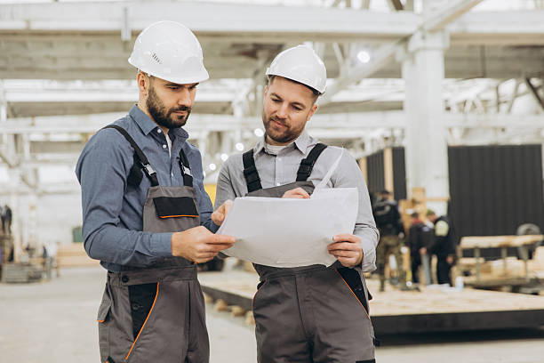 istock Construction workers examining blueprint in modular building factory 2228677889