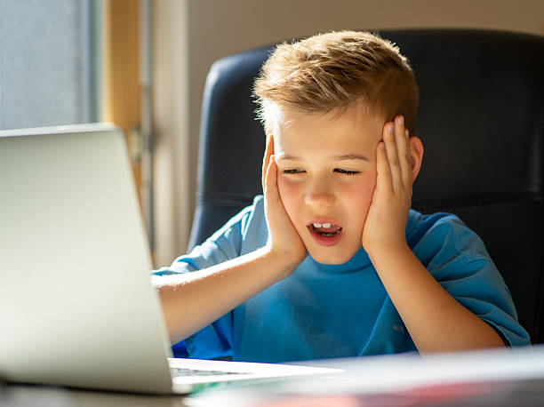 istock A cute boy uses a laptop for online classes with a teacher via video call 2228679248