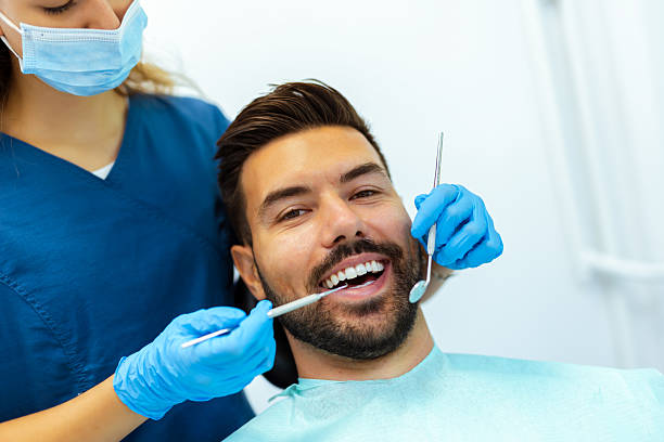 istock Female Dentist Treating Male Patient's Teeth 2228679287