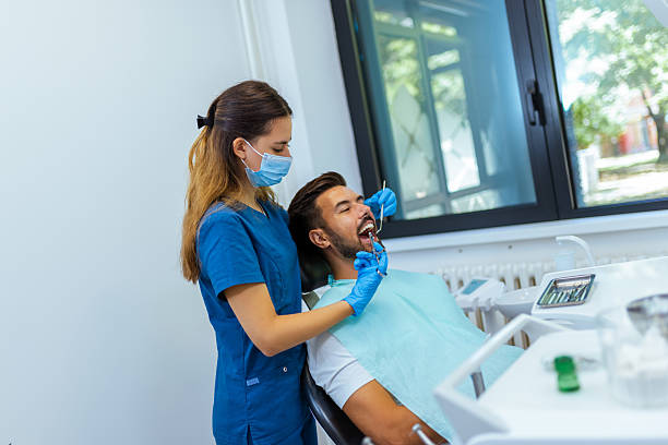 istock Female Dentist Treating Male Patient's Teeth 2228679403
