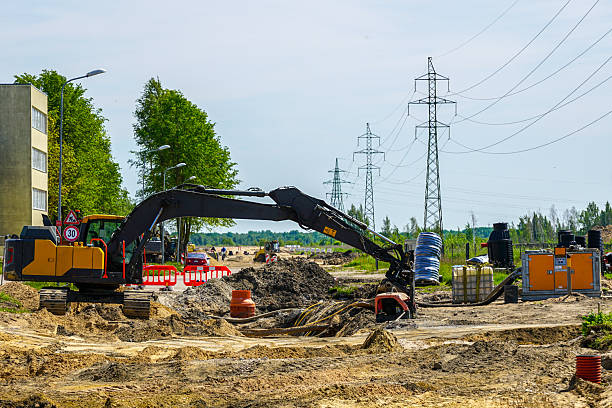 istock Excavator and Dewatering Pump at Urban Construction Site with Power Lines and Pipe Installation 2228682146